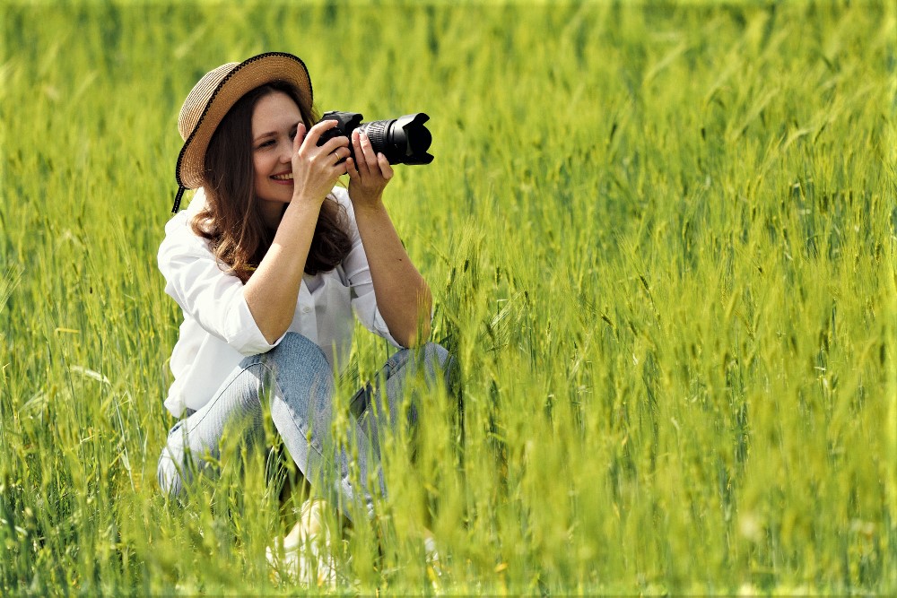 Zdjęcie przedstawia osobę fotografującą przyrodę